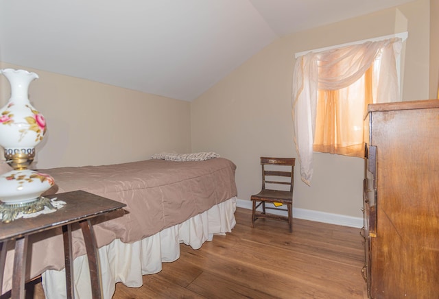 bedroom featuring hardwood / wood-style flooring and lofted ceiling