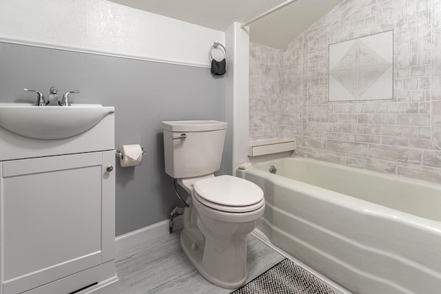 full bathroom with tiled shower / bath, vanity, vaulted ceiling, and toilet