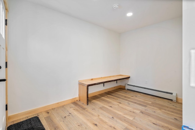 interior space featuring light wood-style flooring, a baseboard heating unit, baseboards, and recessed lighting