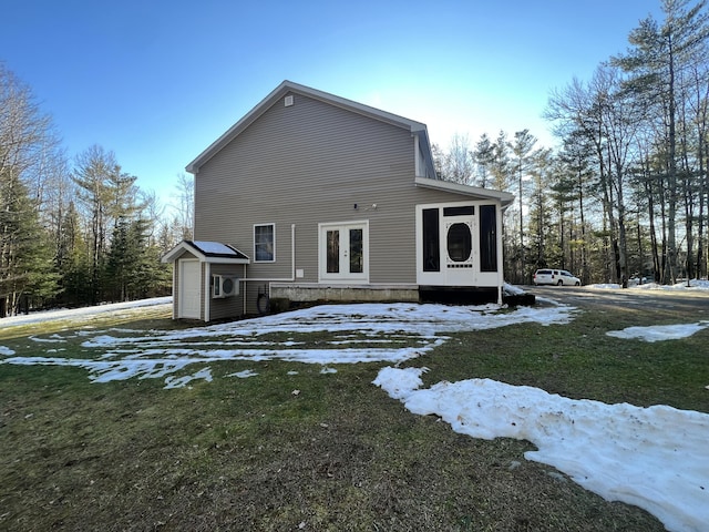 snow covered property featuring french doors and a lawn