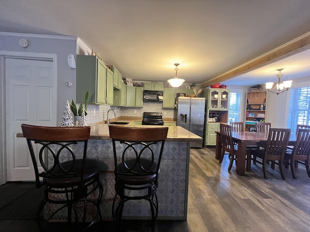 kitchen featuring black appliances, crown molding, green cabinetry, dark hardwood / wood-style flooring, and kitchen peninsula