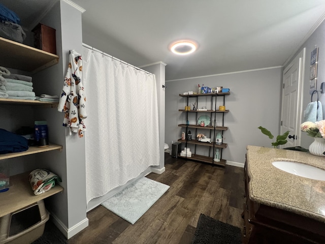 bathroom featuring wood-type flooring, vanity, toilet, and crown molding