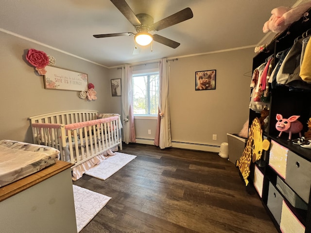 701 Stetson Rd, Exeter, ME 04435 - bedroom featuring wood finished floors, ornamental molding, ceiling fan, a nursery area, and a baseboard radiator