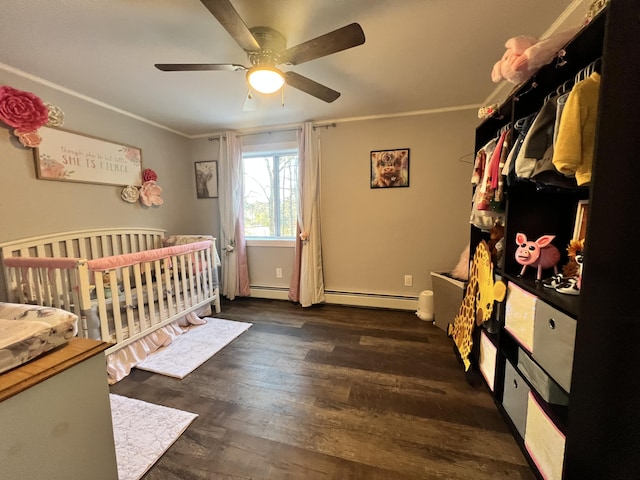 bedroom with crown molding, ceiling fan, dark hardwood / wood-style floors, a baseboard radiator, and a crib