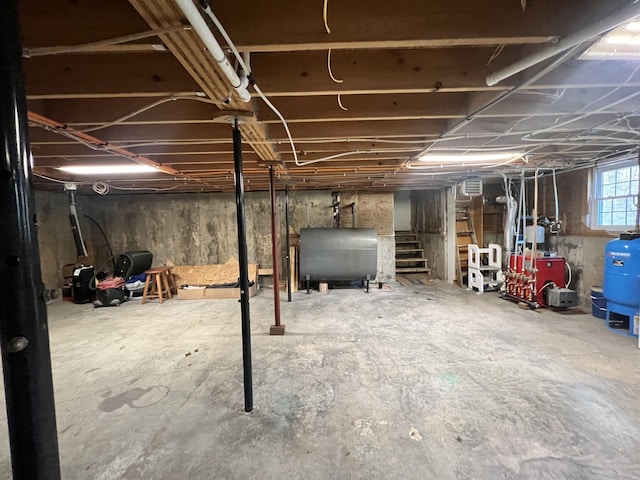 701 Stetson Rd, Exeter, ME 04435 - basement featuring oil tank, stairs, a water pressure tank, and a heating unit