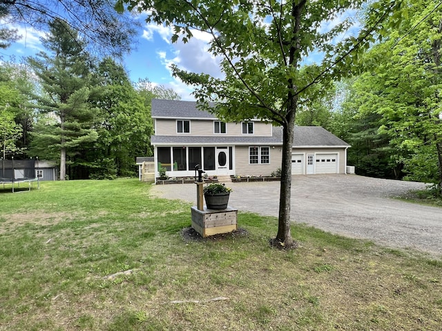 701 Stetson Rd, Exeter, ME 04435 - view of front of home with a sunroom, a trampoline, a garage, driveway, and a front yard