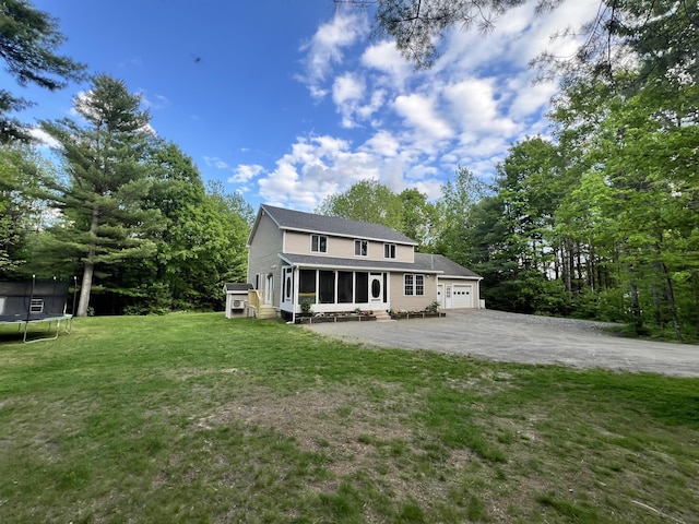 701 Stetson Rd, Exeter, ME 04435 - view of front of house featuring a trampoline, a sunroom, asphalt driveway, an attached garage, and a front lawn