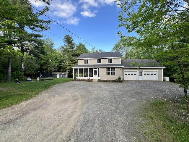 701 Stetson Rd, Exeter, ME 04435 - view of front of property with a sunroom, a trampoline, driveway, an attached garage, and a front yard
