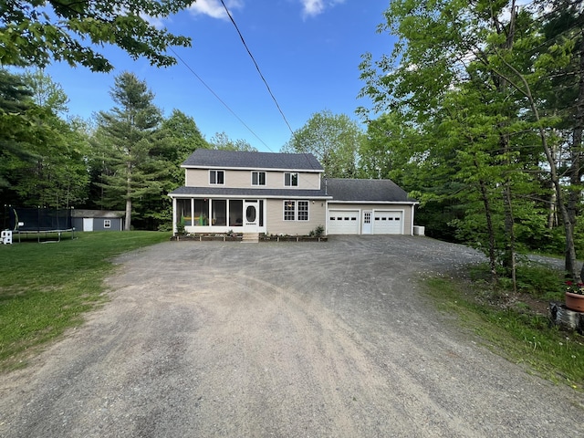 701 Stetson Rd, Exeter, ME 04435 - view of front of house featuring a sunroom, a trampoline, a garage, driveway, and a front lawn