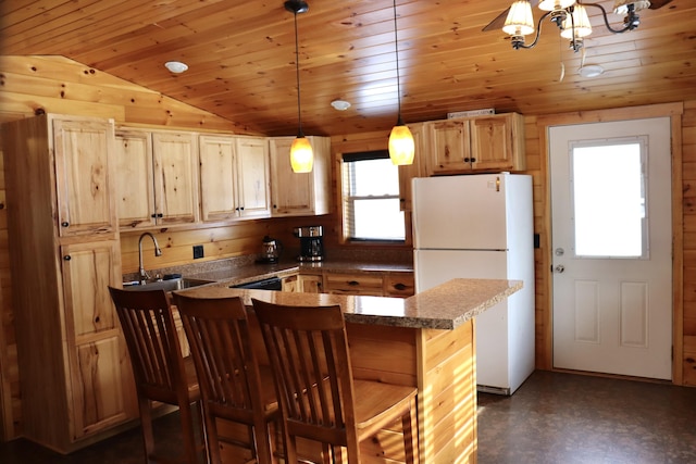 kitchen featuring lofted ceiling, white refrigerator, sink, wood ceiling, and a breakfast bar area