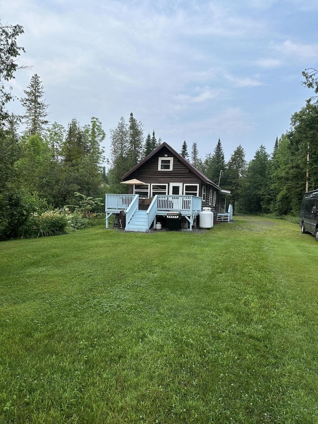 view of front of property with a front yard and a wooden deck