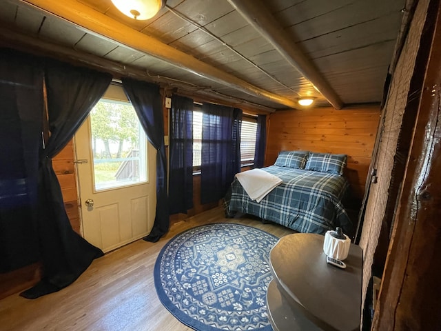 bedroom featuring wood ceiling, wooden walls, beamed ceiling, and wood-type flooring