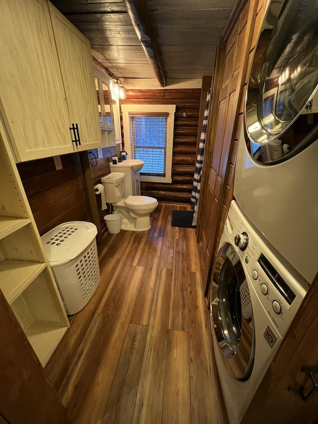 interior space with sink, hardwood / wood-style floors, toilet, wood ceiling, and stacked washer and clothes dryer