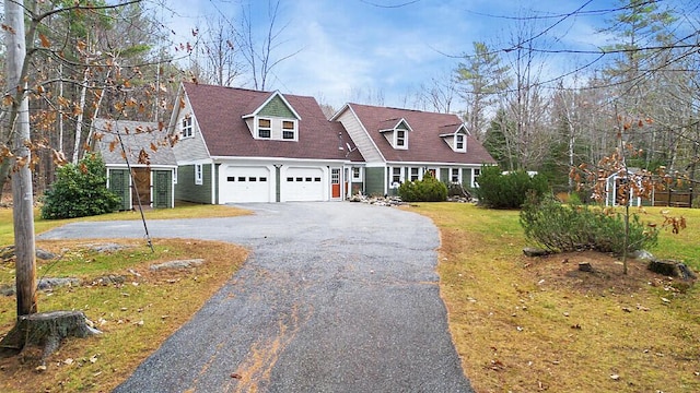 cape cod house with a garage and a front lawn