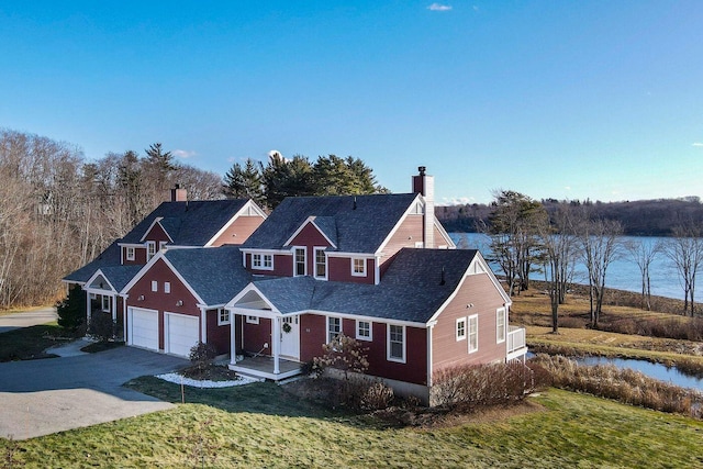 view of front facade featuring a garage, a water view, and a front yard