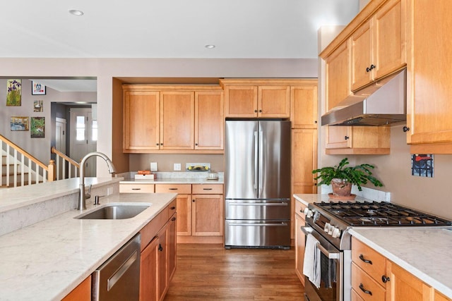 kitchen featuring light stone countertops, appliances with stainless steel finishes, sink, and dark wood-type flooring