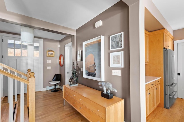 corridor featuring baseboard heating and light hardwood / wood-style flooring