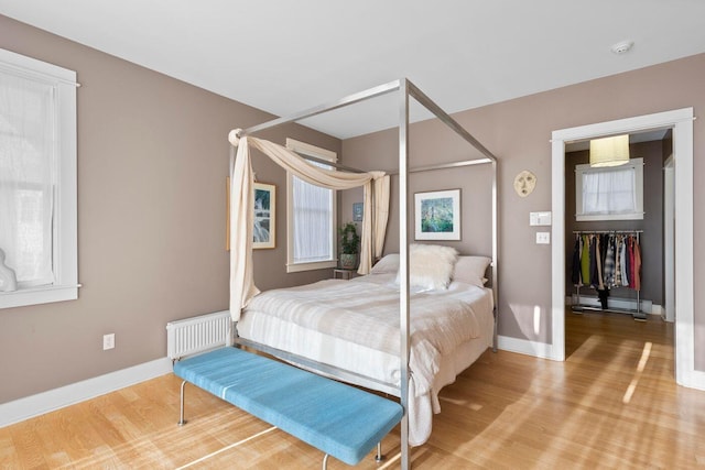 bedroom featuring hardwood / wood-style floors and radiator heating unit