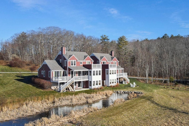 rear view of property with a deck and a lawn