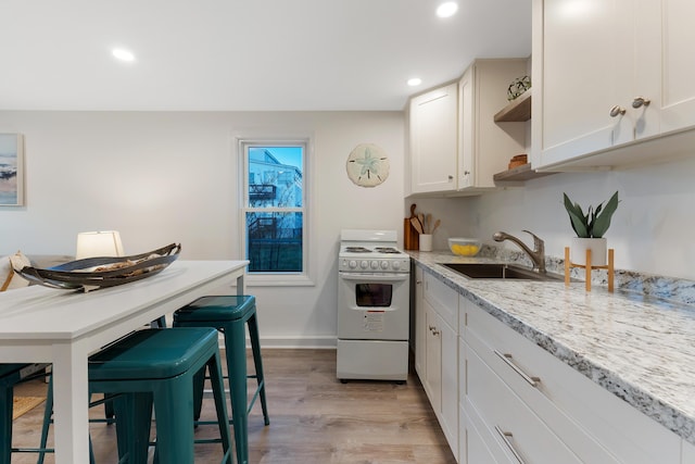 kitchen featuring sink, white cabinetry, light hardwood / wood-style floors, white range with electric stovetop, and light stone countertops