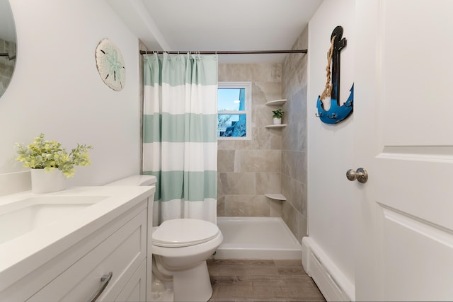 bathroom with a shower with shower curtain, hardwood / wood-style floors, toilet, vanity, and baseboard heating