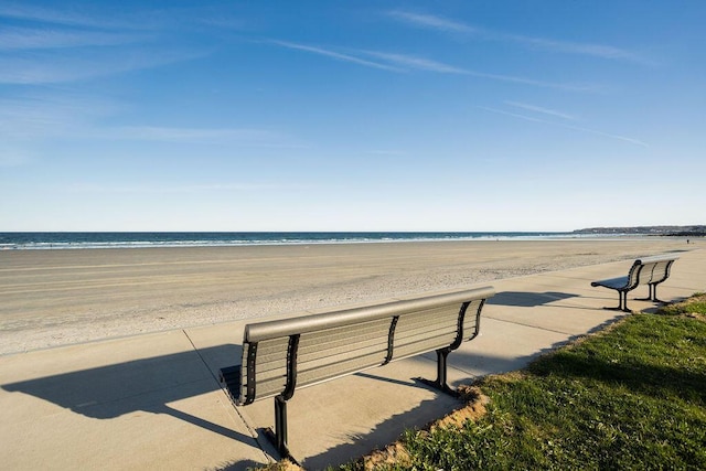 surrounding community with a water view and a view of the beach