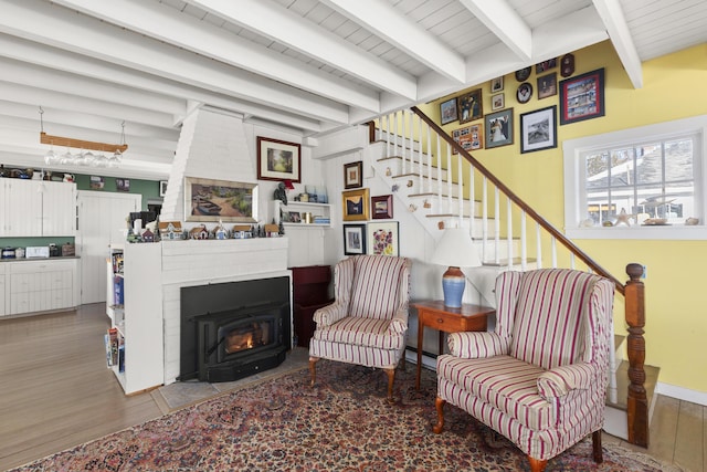 living room with hardwood / wood-style flooring, a fireplace, beamed ceiling, and baseboard heating