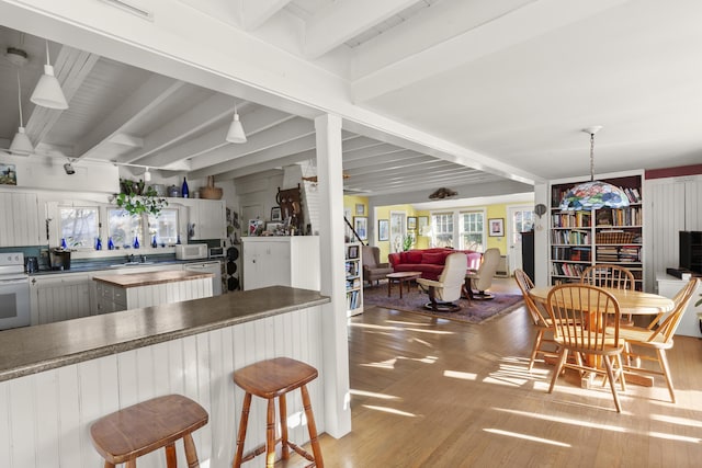 kitchen with butcher block countertops, white appliances, light hardwood / wood-style flooring, and beamed ceiling