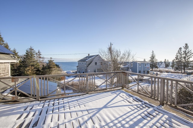 snow covered deck with a water view