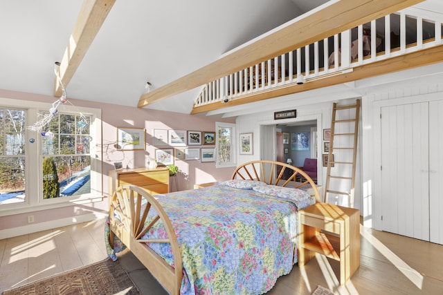 dining area featuring beamed ceiling, plenty of natural light, and hardwood / wood-style flooring