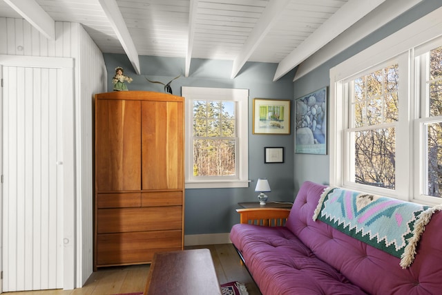 sitting room featuring light wood-type flooring and beam ceiling