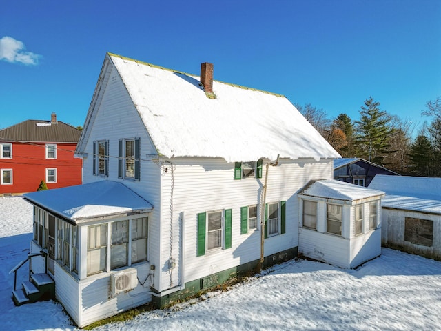 snow covered back of property featuring ac unit