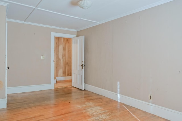 empty room with hardwood / wood-style flooring and ornamental molding