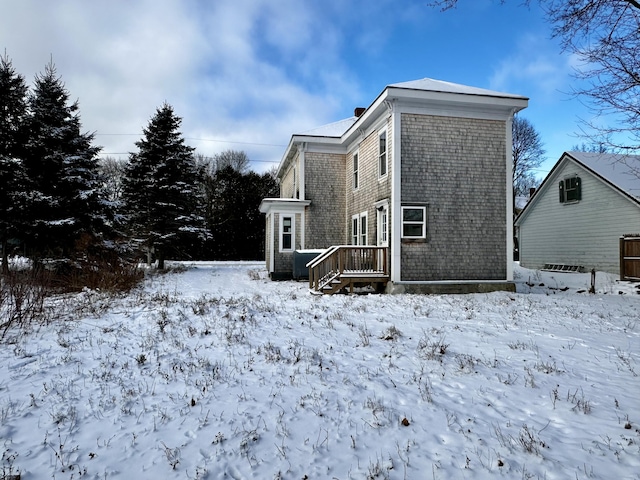 view of snow covered back of property