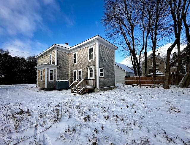 view of snow covered rear of property