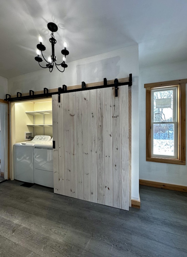 interior space featuring hardwood / wood-style flooring, a barn door, independent washer and dryer, and a chandelier