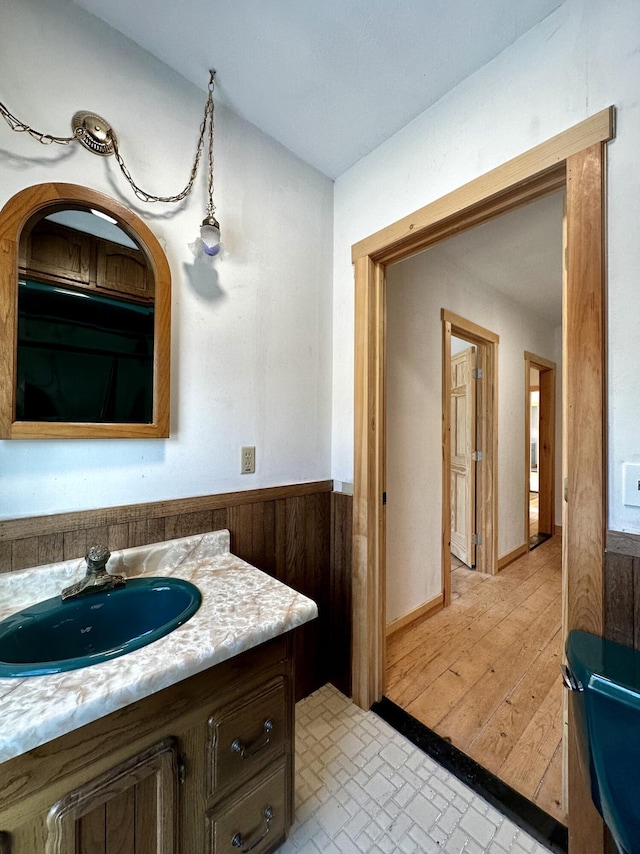 bathroom featuring vanity and wooden walls