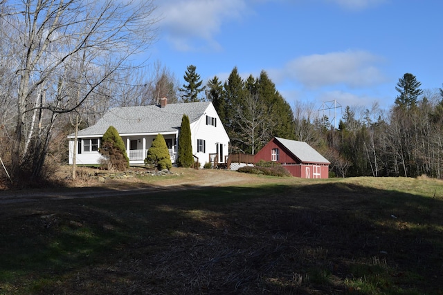 view of property exterior featuring an outdoor structure and a lawn