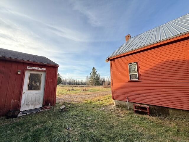 view of property exterior with an outbuilding and a yard