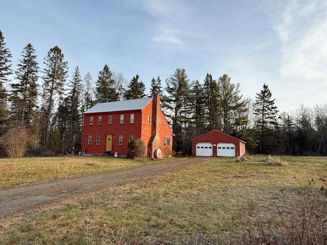 exterior space with an outbuilding, a garage, and a lawn