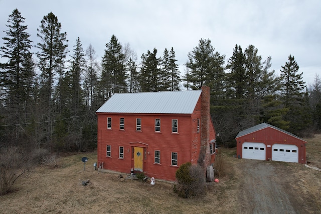 21 Talmadge Rd, Talmadge, ME 04492 - view of front of property with a garage, an outbuilding, dirt driveway, and metal roof