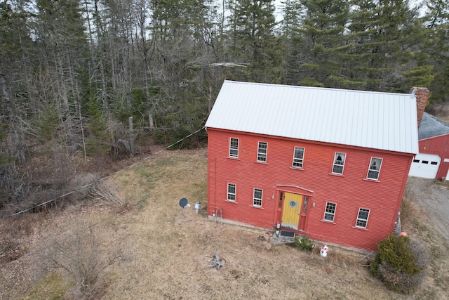 21 Talmadge Rd, Talmadge, ME 04492 - view of front of house with a chimney, metal roof, and a detached garage