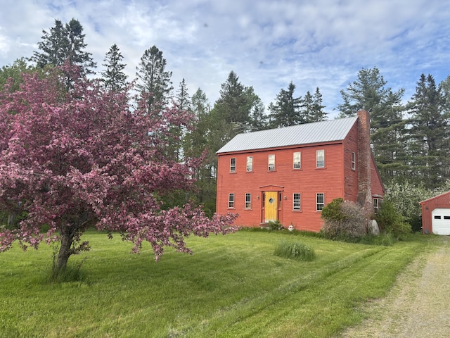 21 Talmadge Rd, Talmadge, ME 04492 - colonial inspired home featuring a front yard, a chimney, metal roof, and a detached garage
