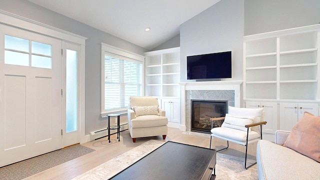 interior space with light wood-type flooring, lofted ceiling, baseboard heating, and a healthy amount of sunlight