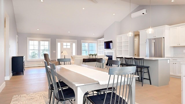 dining room with a wall mounted air conditioner, light wood-type flooring, high vaulted ceiling, and a baseboard heating unit