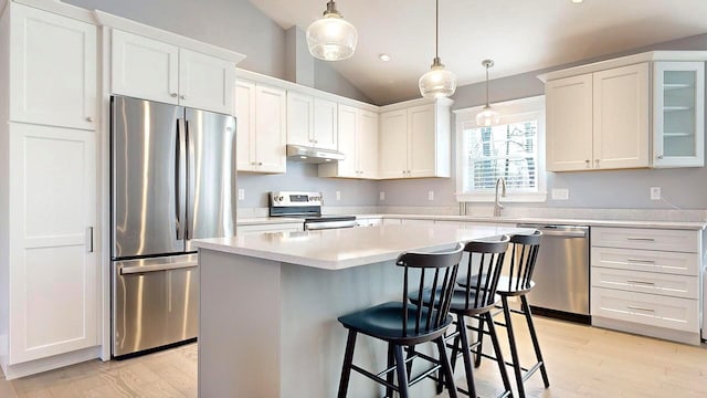 kitchen featuring white cabinets, a kitchen island, lofted ceiling, and appliances with stainless steel finishes