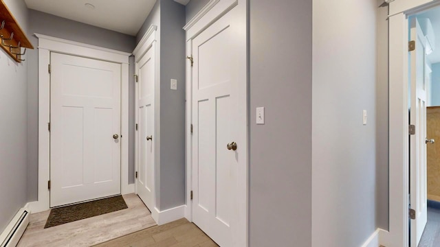 entryway with light hardwood / wood-style flooring and a baseboard heating unit