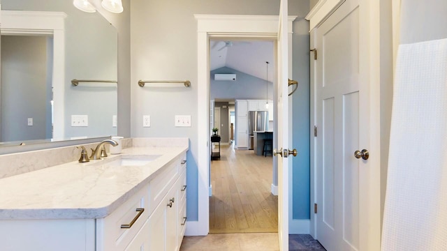 bathroom featuring tile patterned flooring, vanity, and vaulted ceiling