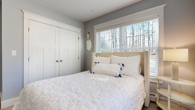 bedroom featuring baseboard heating and a closet