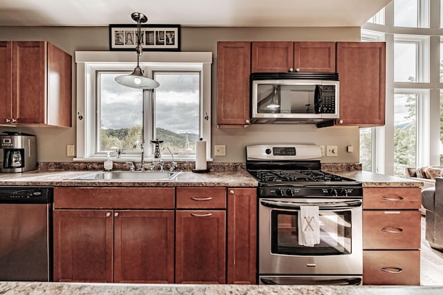 kitchen with sink, decorative light fixtures, and appliances with stainless steel finishes